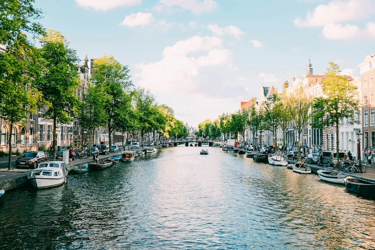 A tree-lined Amsterdam canal with boats
